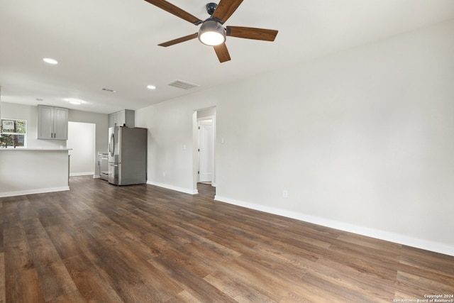 unfurnished living room with dark hardwood / wood-style flooring and ceiling fan