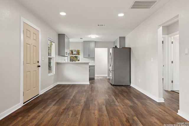 kitchen with stainless steel refrigerator, gray cabinetry, and dark hardwood / wood-style flooring