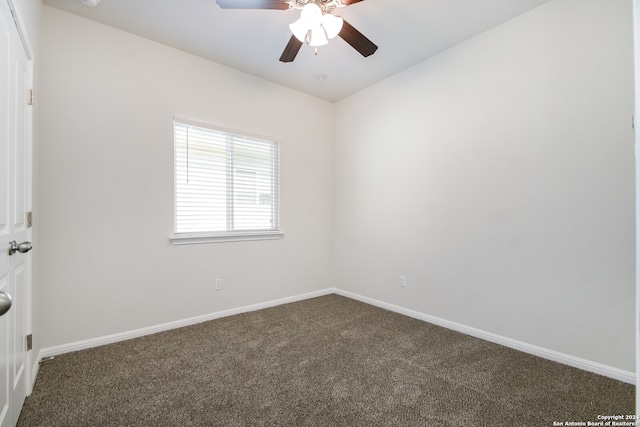 spare room with dark colored carpet and ceiling fan