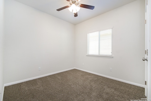 carpeted spare room with ceiling fan