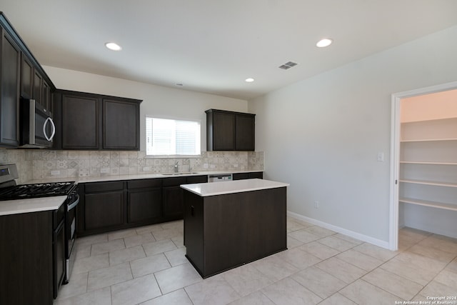 kitchen with light tile patterned floors, decorative backsplash, a center island, and stainless steel appliances