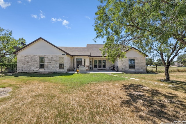 ranch-style home featuring a front lawn and a patio area