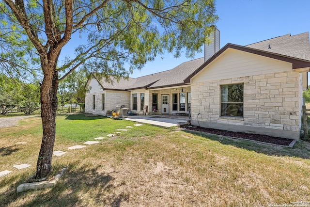 back of house with a lawn and a patio area