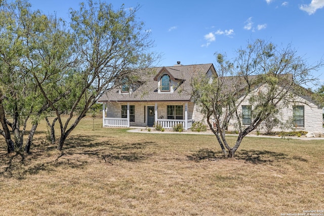 new england style home with a front yard and covered porch