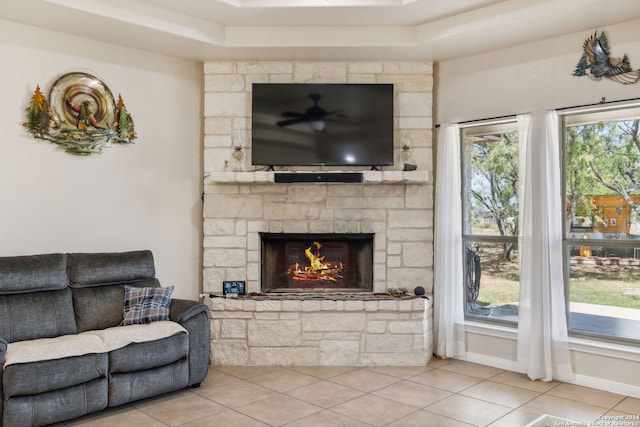 tiled living room with a healthy amount of sunlight, a fireplace, and a raised ceiling