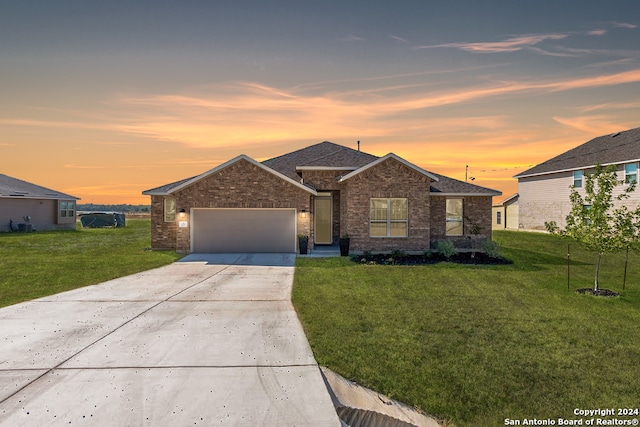 view of front of property with a yard and a garage