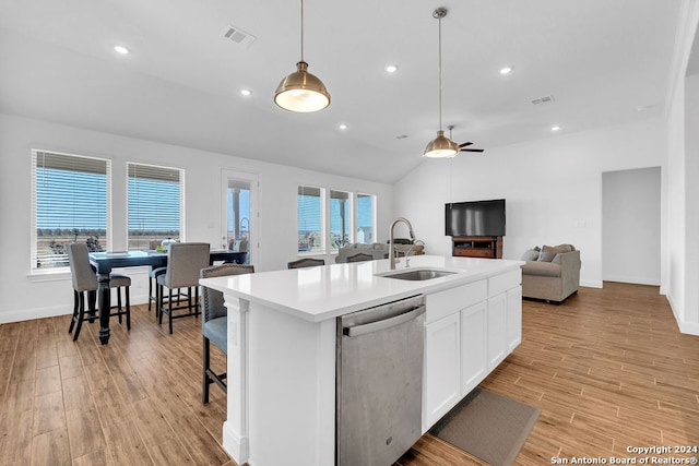 kitchen featuring a wealth of natural light, sink, white cabinetry, a center island with sink, and stainless steel dishwasher