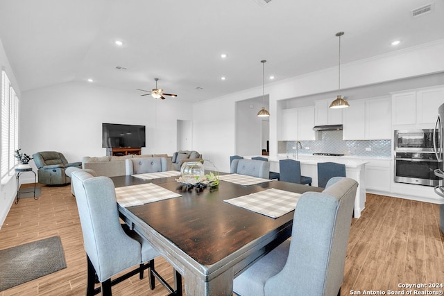 dining area with light hardwood / wood-style floors, ornamental molding, lofted ceiling, and ceiling fan