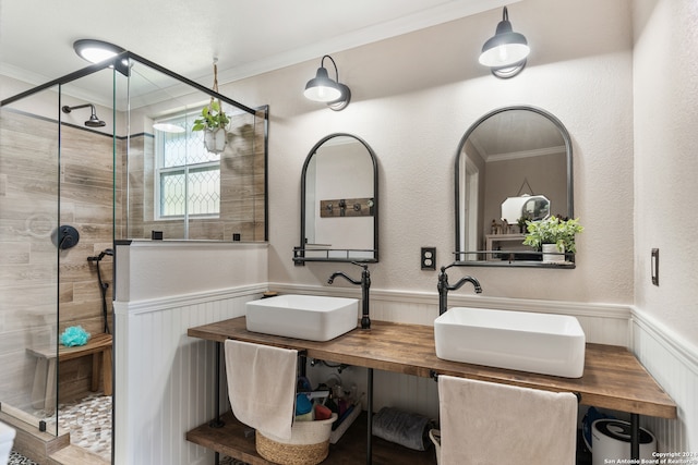 bathroom with vanity, crown molding, and a shower with door