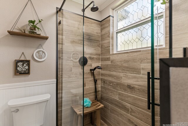 bathroom with walk in shower, crown molding, and toilet