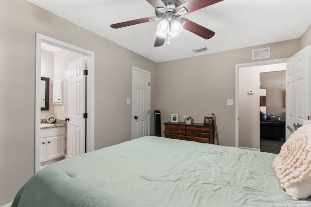 bedroom with ceiling fan, a closet, and ensuite bath