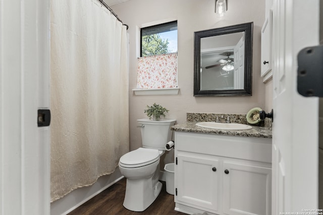 bathroom featuring a shower with shower curtain, hardwood / wood-style floors, ceiling fan, vanity, and toilet