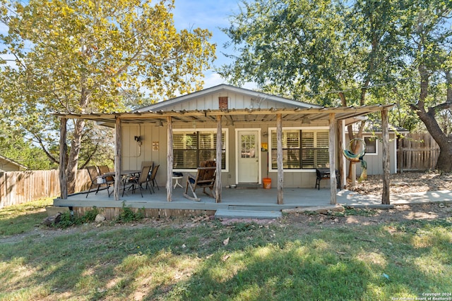 rear view of house with a lawn and a wooden deck