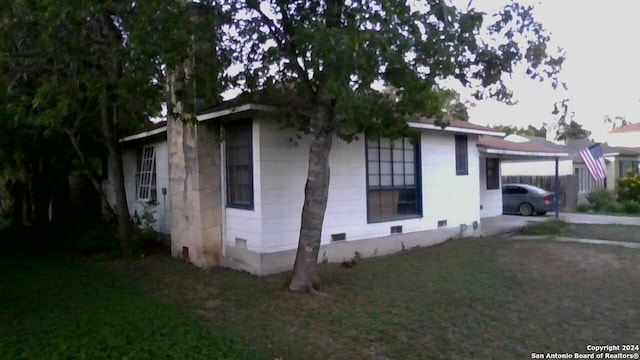 view of side of property with a yard and a carport