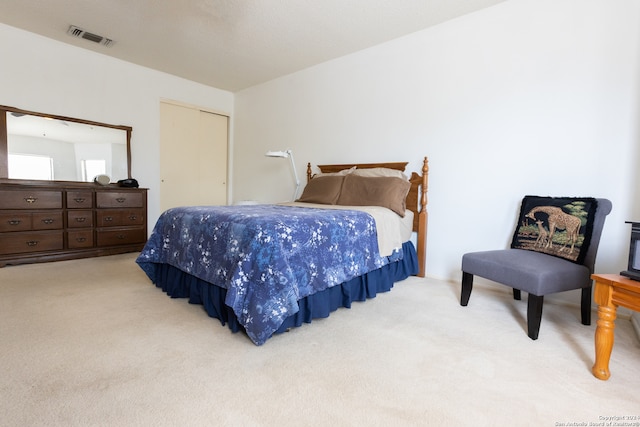 bedroom with light colored carpet and a closet