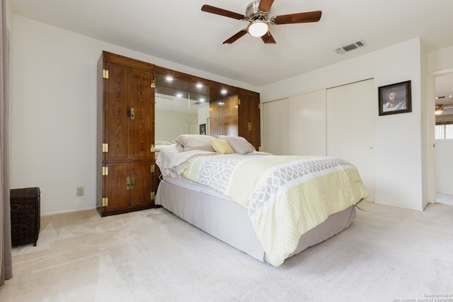 carpeted bedroom with ceiling fan and a closet