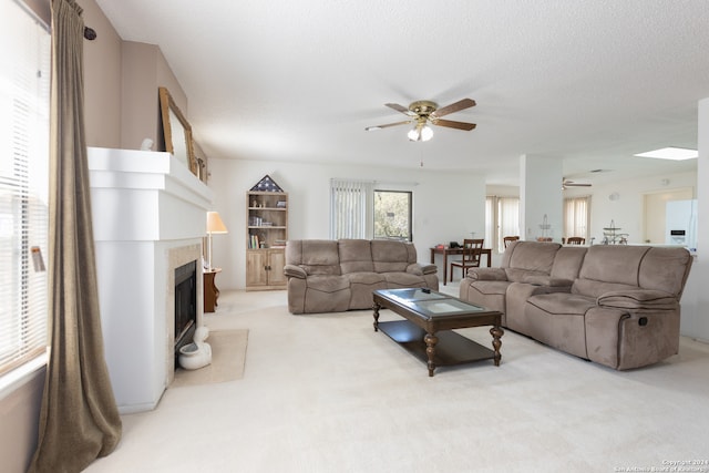 living room with ceiling fan, light colored carpet, and a textured ceiling