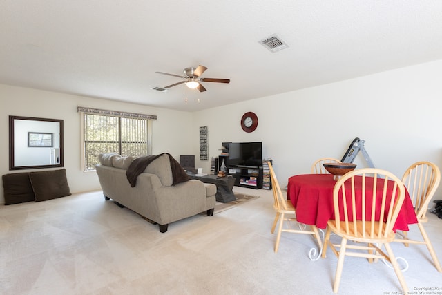 carpeted living room with ceiling fan