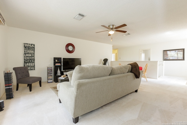 carpeted living room with a textured ceiling and ceiling fan