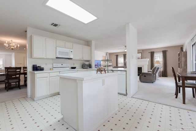 kitchen with ceiling fan with notable chandelier, white cabinets, white appliances, and a kitchen island