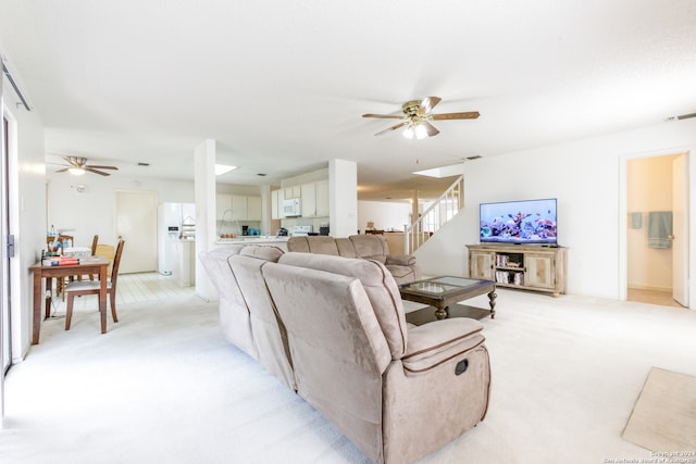 carpeted living room featuring ceiling fan