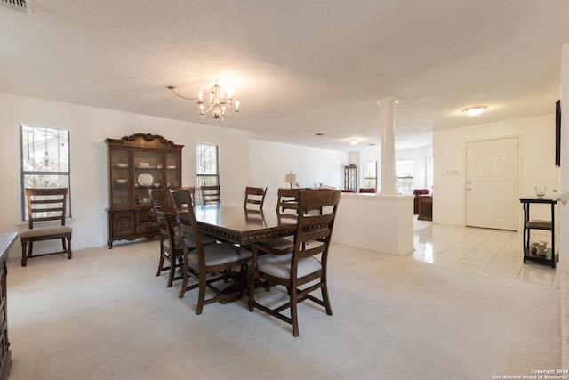 carpeted dining area featuring a textured ceiling, decorative columns, and a healthy amount of sunlight