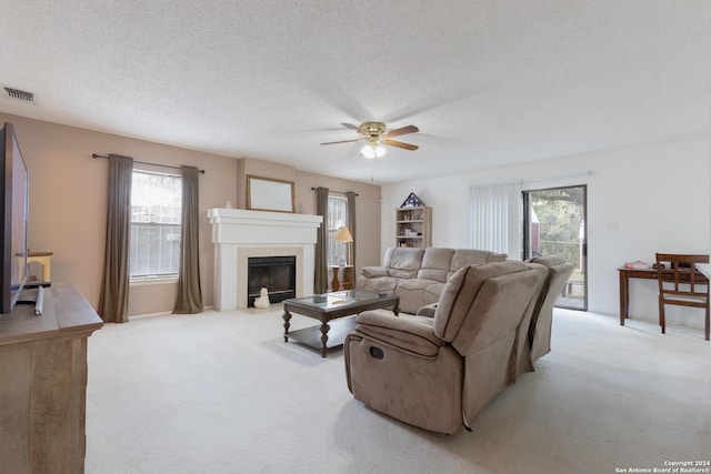 living room featuring light carpet, a textured ceiling, and ceiling fan