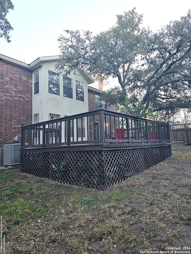 rear view of house with central AC unit and a deck