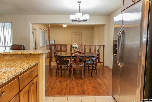 dining space featuring light hardwood / wood-style flooring and a chandelier