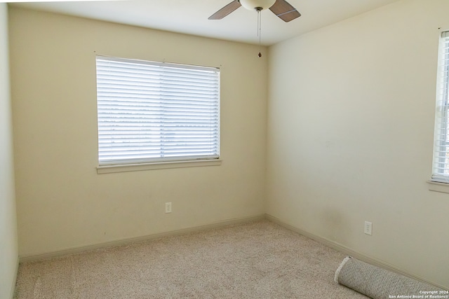 empty room featuring ceiling fan and light carpet