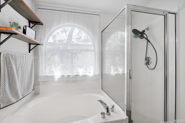 bathroom featuring independent shower and bath