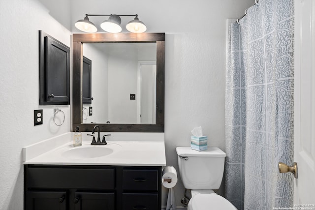 bathroom with curtained shower, vanity, and toilet