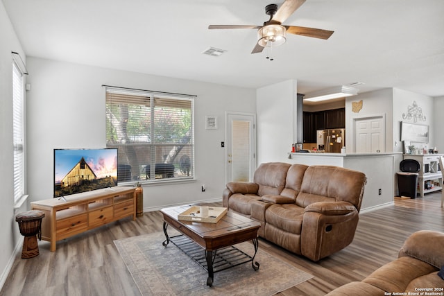 living room featuring light wood-type flooring and ceiling fan