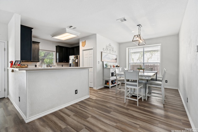 kitchen featuring stainless steel refrigerator with ice dispenser, dark wood-type flooring, and a wealth of natural light