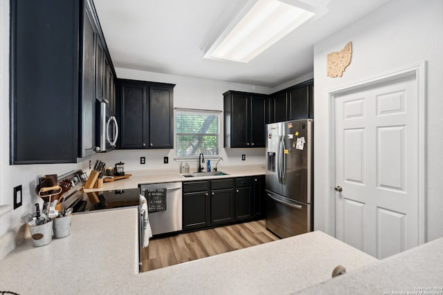 kitchen with stainless steel appliances, light wood-type flooring, and sink