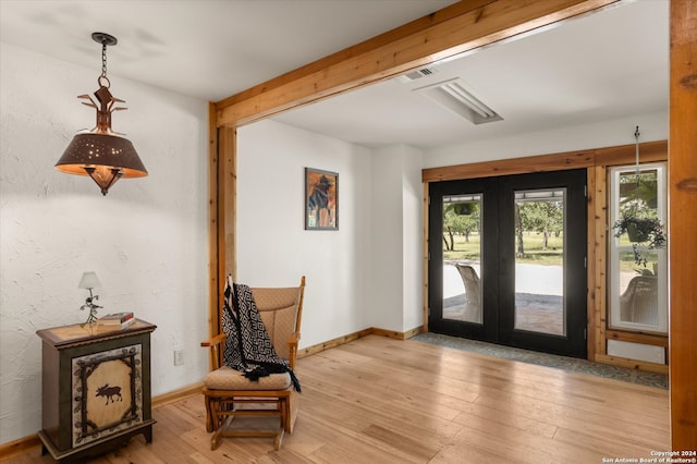 foyer with light hardwood / wood-style floors and french doors