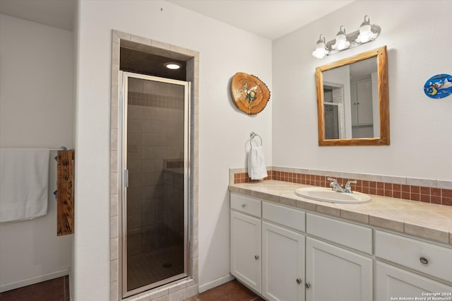 bathroom with a shower with door and vanity