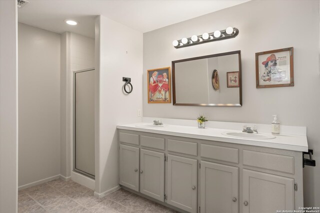 bathroom featuring vanity, a shower with shower door, and tile patterned flooring