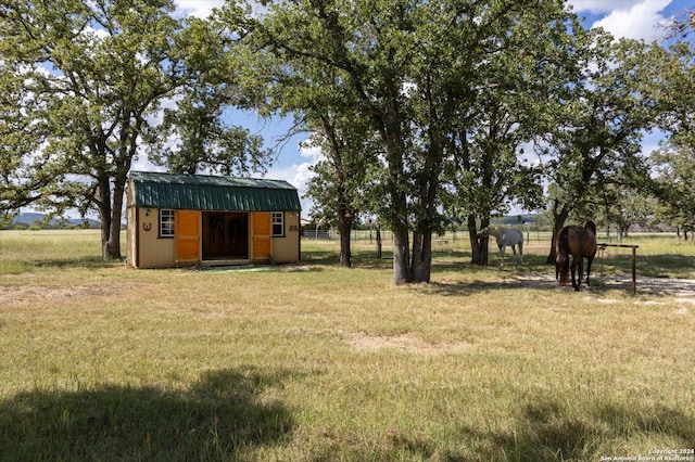 view of yard with a rural view and a storage shed