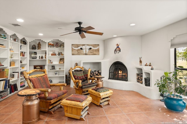 sitting room featuring built in shelves, ceiling fan, and tile patterned floors