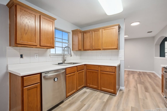 kitchen featuring light hardwood / wood-style floors, tasteful backsplash, appliances with stainless steel finishes, and sink