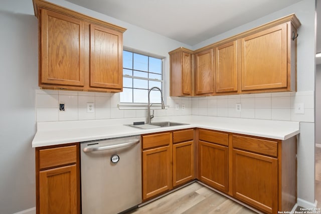 kitchen featuring sink, dishwasher, light hardwood / wood-style floors, and tasteful backsplash