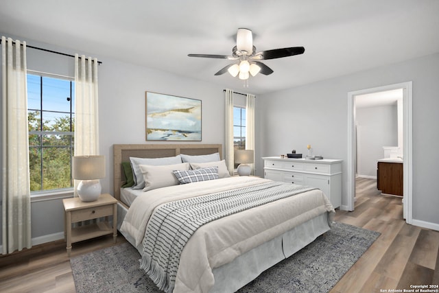 bedroom with light hardwood / wood-style flooring, multiple windows, and ceiling fan