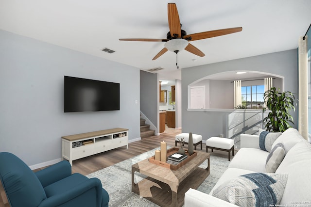 living room featuring dark wood-type flooring and ceiling fan