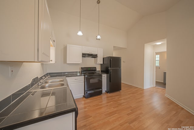 kitchen with hanging light fixtures, high vaulted ceiling, white cabinets, light wood-type flooring, and black appliances