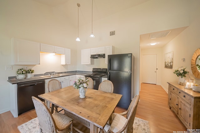 dining area featuring light hardwood / wood-style flooring, sink, and high vaulted ceiling