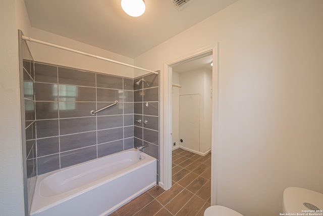 bathroom with tiled shower / bath and toilet