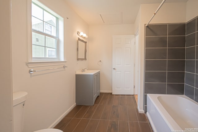 full bathroom with tiled shower / bath, vanity, and toilet