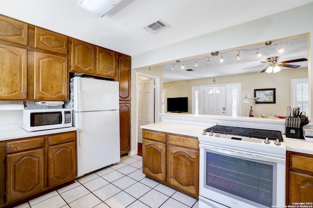 kitchen with white appliances, ceiling fan, light tile patterned floors, and rail lighting