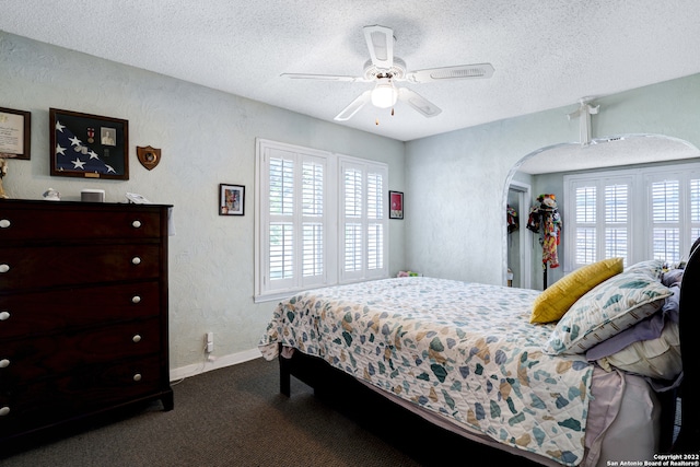 carpeted bedroom with ceiling fan and a textured ceiling